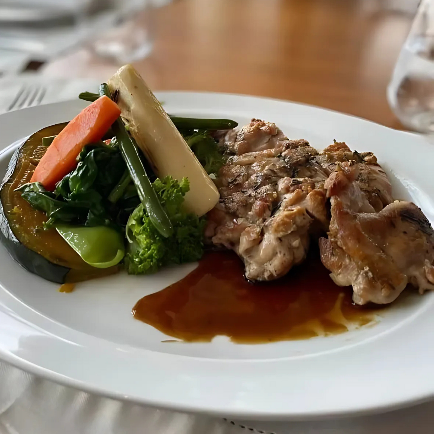 Sobrecoxa de frango orgânico assada ao forno, servida com legumes Piselli.